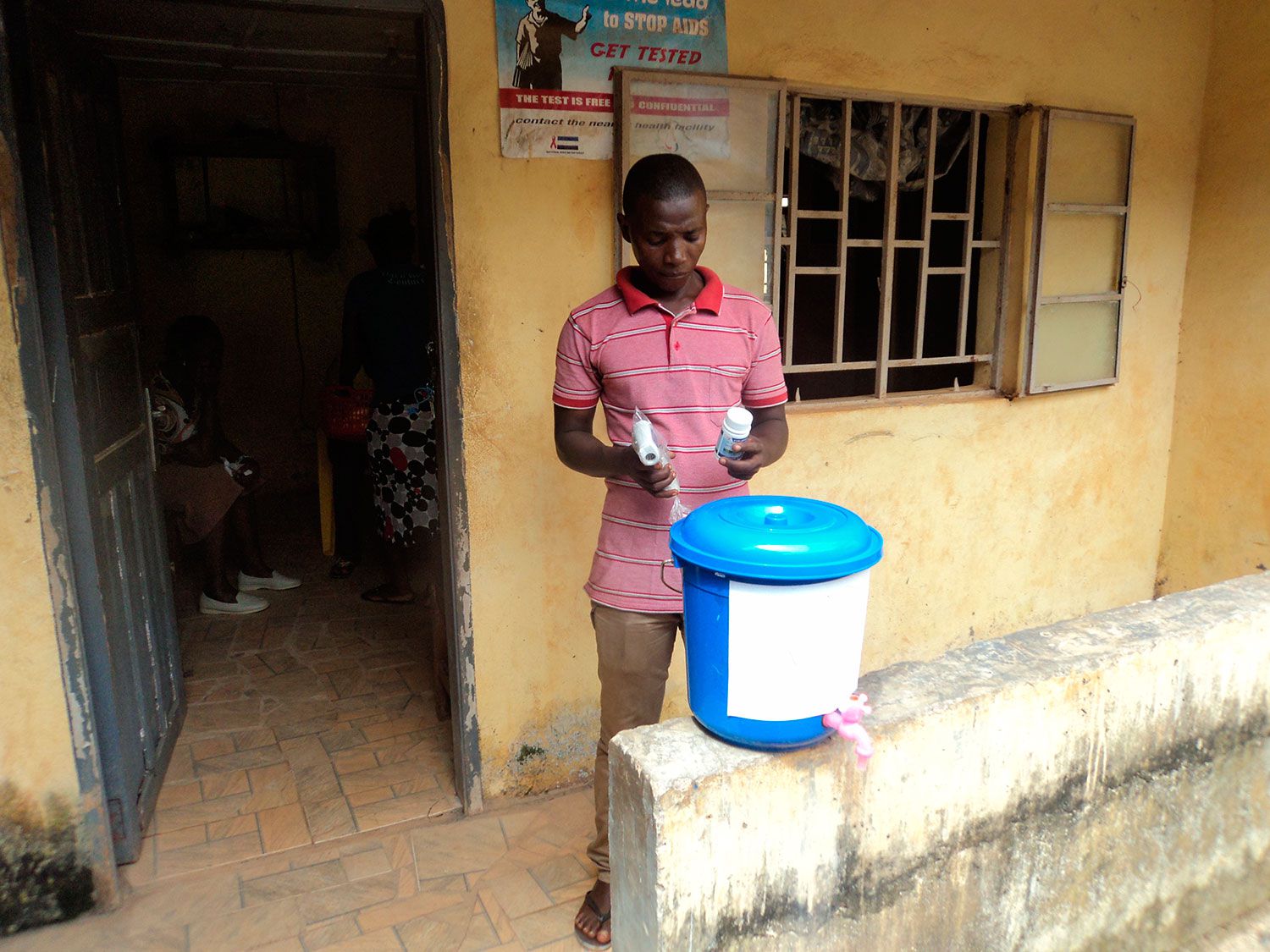 Equipement d'un centre de santé de Freetown avec un seau de désinfectant